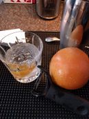 A crystal-clear cocktail in a rocks glass on a bar mat