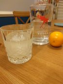 A crystal glass with the cocktail in front of a bottle of Dry Fly vodka and a meyer lemon
